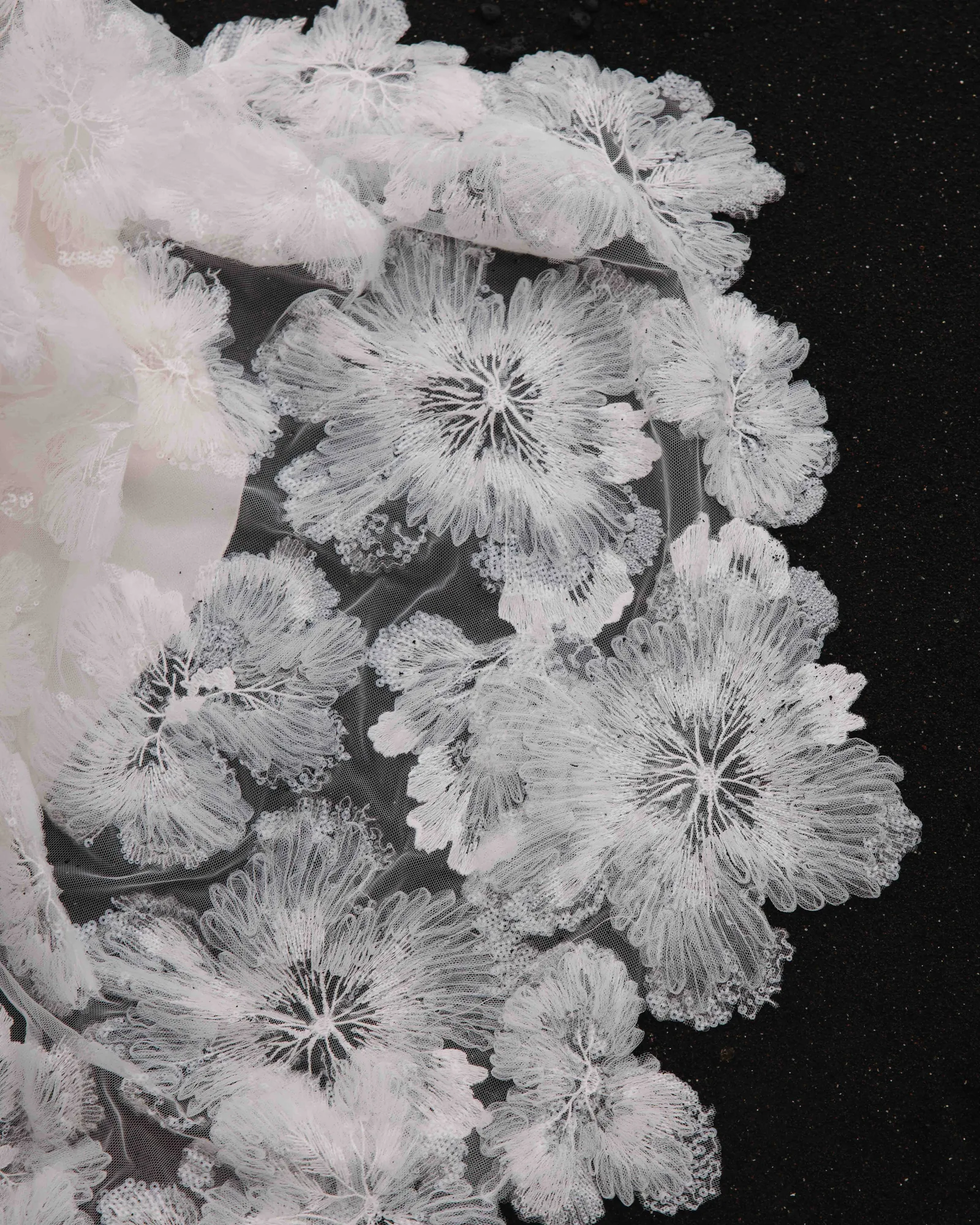 Fleurs de tulle brodé appliquées à la main sur la traîne de la robe 04 de la capsule Meltem