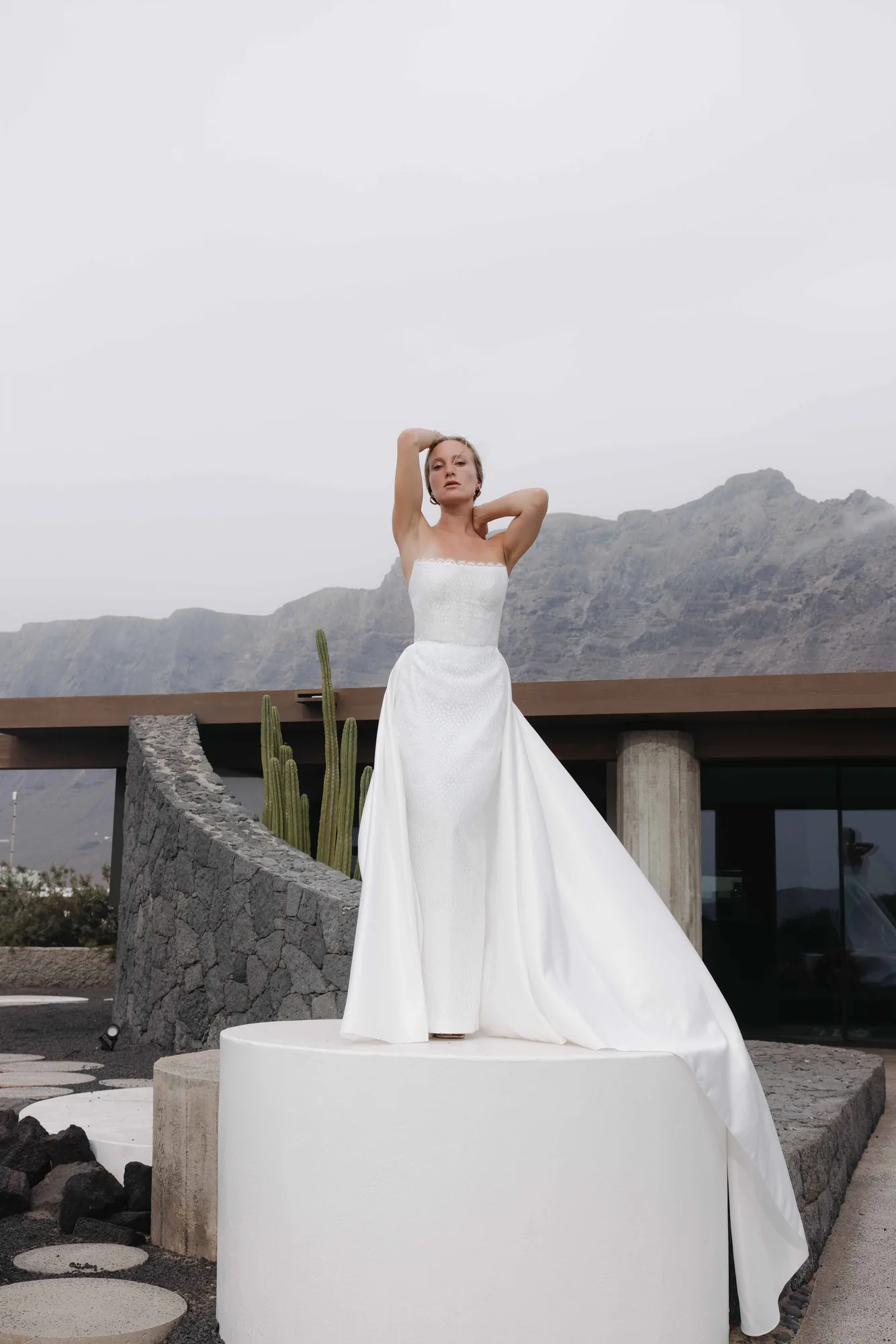 Robe 10 de la capsule Meltem portée de face avec sa surjupe en satin duchesse, sur un socle blanc